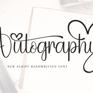 May include: A black and white image of the word "Autography" written in a cursive font with a heart symbol in the "o" of "Auto" and a large heart symbol to the right of the word. The text "NEW SCRIPT HANDWRITTEN FONT" is below the word.