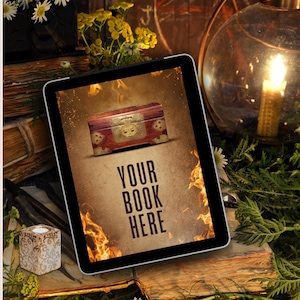 May include: A digital tablet displaying a graphic of a wooden chest with brass hardware centered above the text YOUR BOOK HERE, surrounded by stylized orange flames on a textured tan background, presented in a vertical orientation.