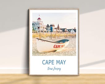 Może przedstawiać: Biała łódź ratunkowa z czerwonym napisem "CAPE MAY" na plaży przed kolorowymi domami. Tekst "CAPE MAY" i "New Jersey" znajduje się pod obrazem.