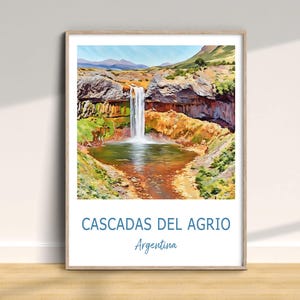 Może przedstawiać: Oprawiony wydruk przedstawiający wodospad. Grafika przedstawia wodospad wpadający do zbiornika wodnego, otoczony skalistymi klifami i zieloną roślinnością. Tekst "CASCADAS DEL AGRIO Argentina" jest wydrukowany na dole.