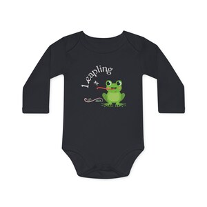 Puede incluir: Un body de bebé de manga larga azul oscuro con un gráfico de rana blanca y el texto "Leapling est. 2024".