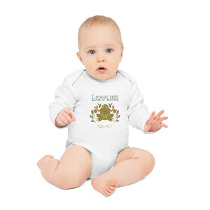 Puede incluir: Mono blanco de manga larga para bebé con una ilustración de rana verde y el texto "Leapling" en gris.