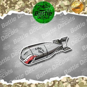May include: A gray and white cartoon bomb with a shark mouth and the words "Little Boy" written on it. The bomb is on a silver background with the words "Battle Decals" repeated around the edges.