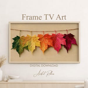 Könnte beinhalten: Ein digitaler Download für Frame TV Kunst mit fünf texturierten Ahornblättern in einem Farbverlauf von Grün, Gelb, Orange, Rot und Dunkelburgunder, die an einer dünnen braunen Schnur vor einem neutralen beigen Hintergrund hängen.