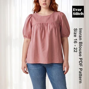 Puede incluir: Una blusa rosa polvoriento con mangas cortas abullonadas y un canesú bordado. La blusa se combina con unos vaqueros azules. La imagen incluye el texto "Ever Stitch" y "Imran Blouse PDF Pattern Size 16 - 22".