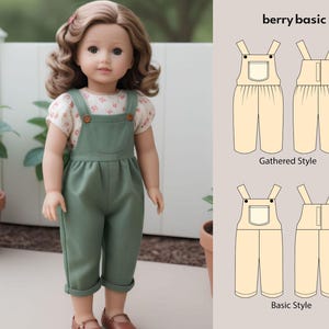 Peut inclure: Une poupée porte une salopette verte et un haut fleuri blanc. La salopette a des boutons en bois et une poche avant. La poupée a les cheveux bruns et porte des chaussures marron. L'image comprend un schéma du design de la salopette avec le texte "berry basic".