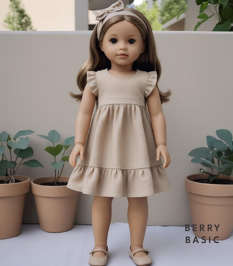 K&ouml;nnte beinhalten: Eine Puppe in einem beigefarbenen Kleid mit R&uuml;schen&auml;rmeln und -saum, passenden Schuhen und einem Stirnband. Die Puppe hat lange braune Haare und steht vor einem neutralen Hintergrund. Der Text "BERRY BASIC" ist sichtbar.