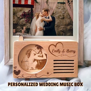 May include: Personalized wooden music box with a photo of a couple kissing and the text "Emilly & Barry" engraved on the front. The music box is shaped like a vintage radio.