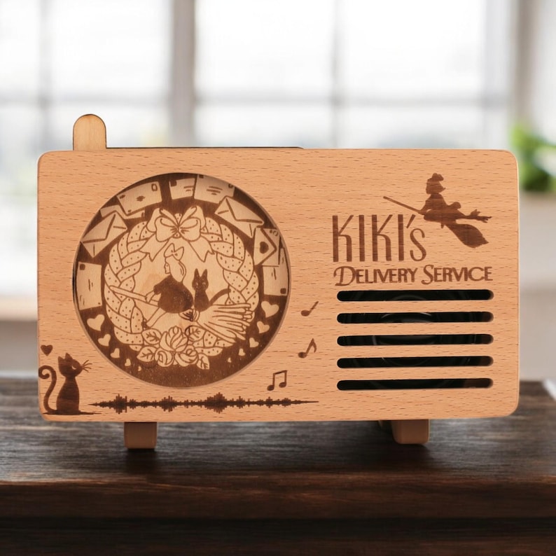 May include: A wooden music box with a laser-engraved design featuring Kiki's Delivery Service characters and the text "Kiki's Delivery Service".