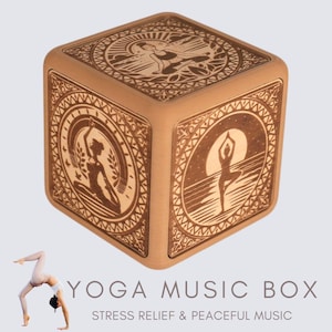 May include: A wooden music box shaped like a cube. The box is decorated with intricate designs and images of yoga poses. The text "YOGA MUSIC BOX" and "STRESS RELIEF & PEACEFUL MUSIC" is printed on the front of the box.