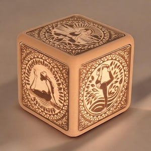 May include: A wooden box with a decorative design featuring women in yoga poses. The box is made of light brown wood and has a square shape.
