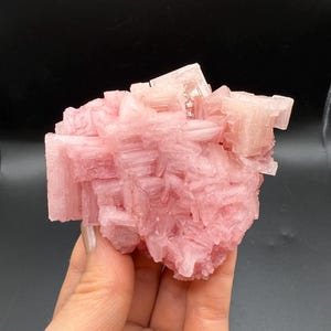 May include: A cluster of pink Himalayan salt crystals with a rough, textured surface.