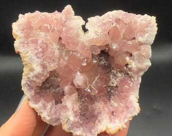 May include: A pink amethyst geode with a large cavity filled with smaller crystals. The geode is about 4 inches wide and 3 inches tall.