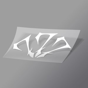 Pode incluir: Um autocolante de vinil branco com um design gráfico estilizado de bordos afiados com elementos angulares e pontiagudos. O autocolante é apresentado numa folha de suporte translúcida, exibindo uma estética limpa e de alto contraste.