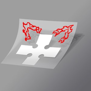 May include: A white cross sticker with two red, flame-like designs on either side.