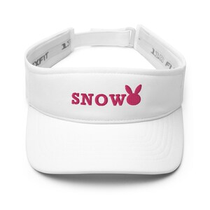 Puede incluir: Visera blanca con un conejo bordado en rosa y la palabra "SNOW" en la parte delantera.