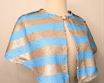 Il mantello Josephine - Mantellina corta da festival con paillettes a righe blu e argento.