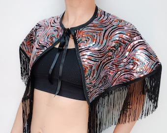 Peacock feather pattern sequinned cape with black fringing and black ribbon fastening