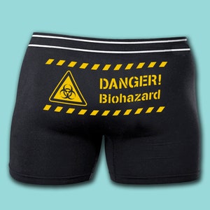 May include: Black boxer shorts with a yellow biohazard symbol and the text "DANGER! Biohazard" printed on the back.