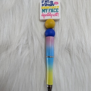 May include: A white ceramic mug with a black handle and the text "But First, Coffee" in a bold, black font. The mug is displayed on a white surface. The mug is approximately 4 inches tall.