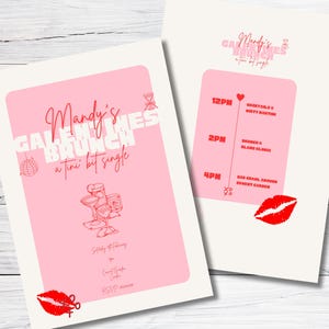 May include: Pink invitation with white text that reads "Mandy's Galentine's Brunch a tiny bit single". The invitation has a red heart, a red lip, and a drawing of a cocktail glass.