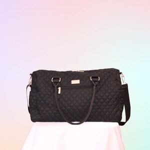 May include: A black quilted travel bag with gold hardware and a shoulder strap.