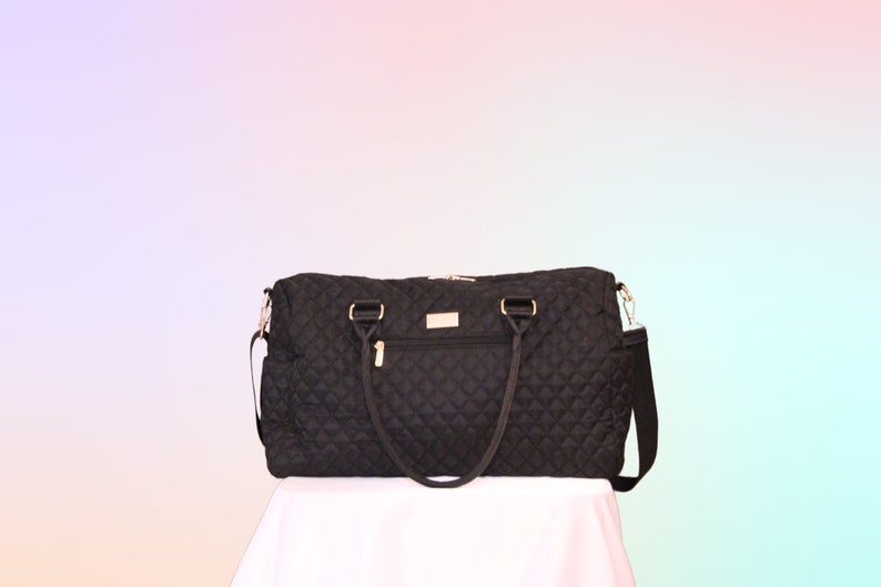 May include: A black quilted travel bag with gold hardware and a shoulder strap.