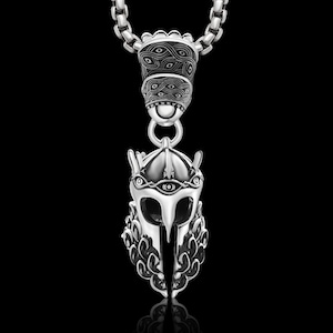 May include: Silver tone necklace with a pendant featuring a detailed warrior helmet with a single eye and a decorative top. The chain is a box style chain.