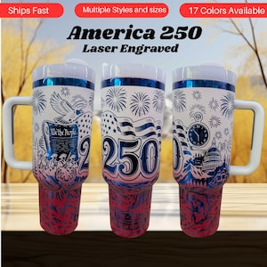May include: Three white travel mugs with blue and red patriotic designs. Each mug features a different illustration, including an eagle, American flag, and the Capitol building. The mugs have white handles and lids, with the text "America 250" and "Laser Engraved".
