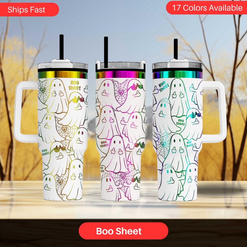 three colorful tumblers with a ghost design on them, arranged on a table against a blurred background.