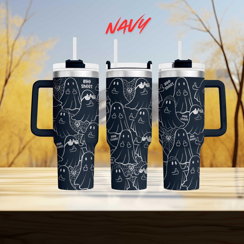 three black tumblers with a repeating pattern of ghost-like figures on their surfaces. The tumblers have handles on the sides, suggesting they are designed for easy carrying. The background of the image is blurred, but it appears to be a wooded area with trees and a blue sky.
