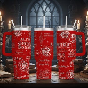 May include: Red insulated tumbler with a handle, featuring white text and rose graphics. The tumbler has the text "ALI'S SMUTTY BOOK CLUB" and other phrases. Includes a white straw and a silver lid.