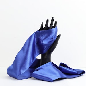 May include: A blue satin ribbon tied around a black hand mannequin. The ribbon is long and flowing, with a soft, luxurious texture.