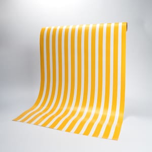 May include: A roll of yellow and white striped paper. The paper is rolled up and the end is visible.