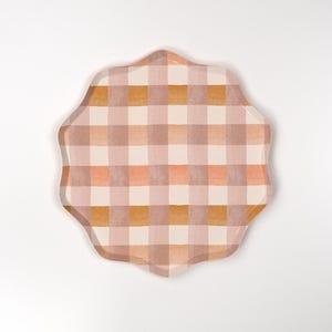 May include: A scalloped paper plate with a pink, orange, and brown gingham pattern.