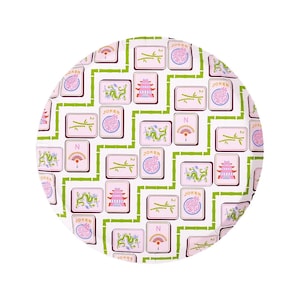 May include: A round, white plate with a repeating pattern of pink and green Mahjong tiles. The tiles feature various symbols like dragons, fans, and bamboo, framed by green bamboo stalks. The word "Joker" is visible on some tiles.