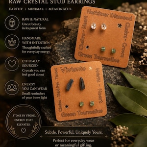 May include: Two brown cardboard display cards featuring raw crystal stud earrings. One card holds clear Herkimer Diamond and green Tourmaline studs. The other card displays dark, elongated Tourmaline and small green Tourmaline studs with the text Viviente.