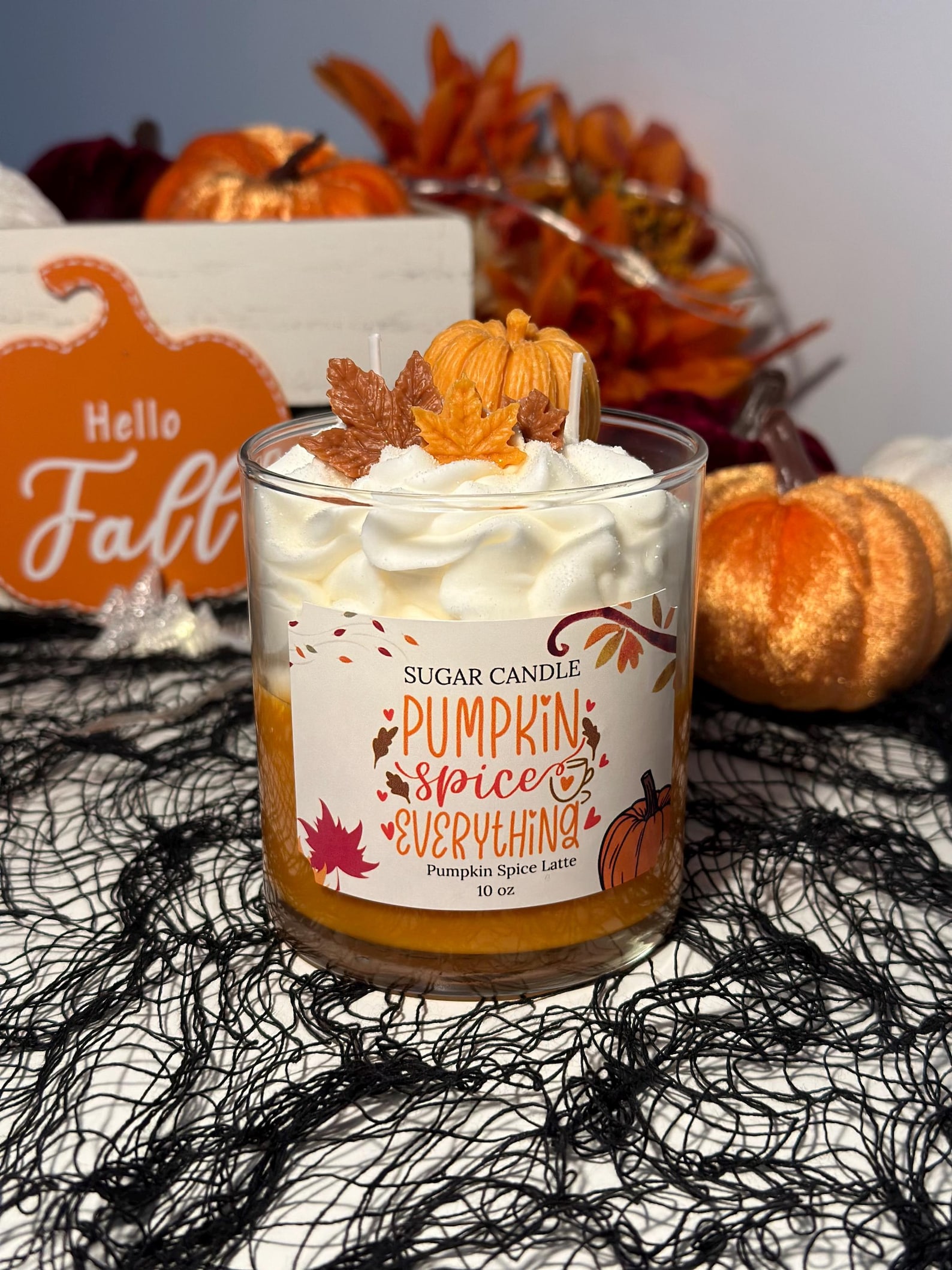 An orange and white pumpkin spice latte candle in a glass jar
