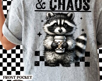 Op de afbeelding: Grijs T-shirt met een verweerde look met een wasbeer die een koffiebeker vasthoudt en de tekst "Caffeine & Chaos".