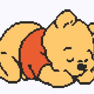 May include: A pixel art illustration of a yellow bear with a round head and small ears, wearing a red shirt. The bear is depicted in a sleeping position, lying on its side with eyes closed and head resting on its front paws, outlined in black.