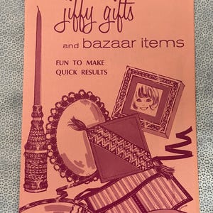 May include: A vintage pink brochure with the text "jiffy gifts and bazaar items". The brochure features illustrations of various craft projects, including a framed portrait, a candle, and decorative items. The text "Fun to Make Quick Results" is also included.
