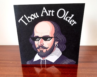 May include: A square greeting card with a black background featuring a pixel art illustration of William Shakespeare wearing pixelated black sunglasses. The text "Thou Art Older" is printed in white above the portrait of the bearded figure.