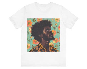 May include: A white t-shirt featuring a colourful graphic print of a person with an afro hairstyle. The graphic depicts a person against a floral backdrop.