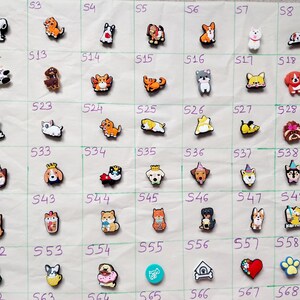 May include: A collection of 60 colourful cartoon animal shoe charms, featuring a variety of dogs, cats, and other animals. The charms are arranged in a grid pattern on a white background.