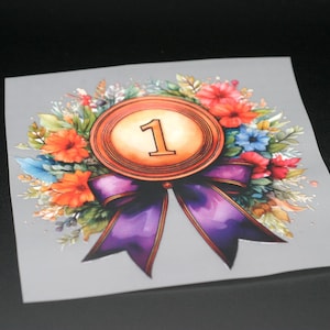 Könnte beinhalten: Eine Goldmedaille mit einem violetten Band und einem Blumenkranz. Die Medaille trägt die Nummer "1".