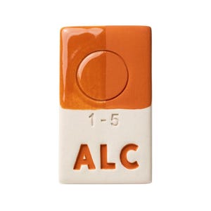 May include: A rectangular ceramic tile with a two-tone design. The top half is orange with a glossy finish and a circular indentation. The bottom half is off-white with the text "1-5" and "ALC" in orange.