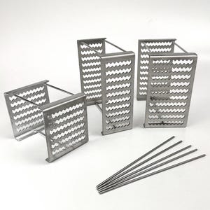 Pode incluir: Quatro grelhas de grelhar de metal prateado com um padrão ondulado e seis espetos de metal prateado.