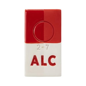 Peut inclure: Objet rectangulaire en céramique, rouge et blanc. La moitié supérieure est rouge avec une indentation circulaire. La moitié inférieure est blanche avec les chiffres "2-7" et les lettres "ALC" en rouge.