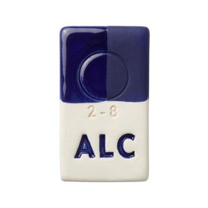 May include: A rectangular ceramic tile with a glossy finish. The top half is divided into two shades of blue, with a circular indentation. The bottom half is white with the text "2-8" and "ALC" in blue.