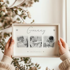 May include: A framed print featuring the word "Granny" in cursive. The frame contains three black and white photographs of a grandmother with a baby. The text "Lots Of Love Lily xx" is below the photos.